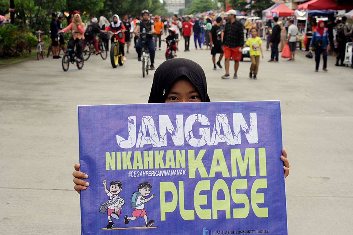 Seorang anak membawa poster saat aksi peringatan Hari Perempuan Internasional di Makassar, Sulawesi Selatan, Minggu (8/3/2020). Aksi tersebut untuk mensosialisasikan pencegahan perkawinan anak guna menekan angka perkawinan usia dini yang masih marak terjadi.
