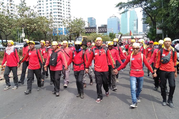 massa aksi dari kelompok buruh lakukan long march ke gedung DPR RI, Senayan, Jakarta Pusat, Senin (30/9/2019)