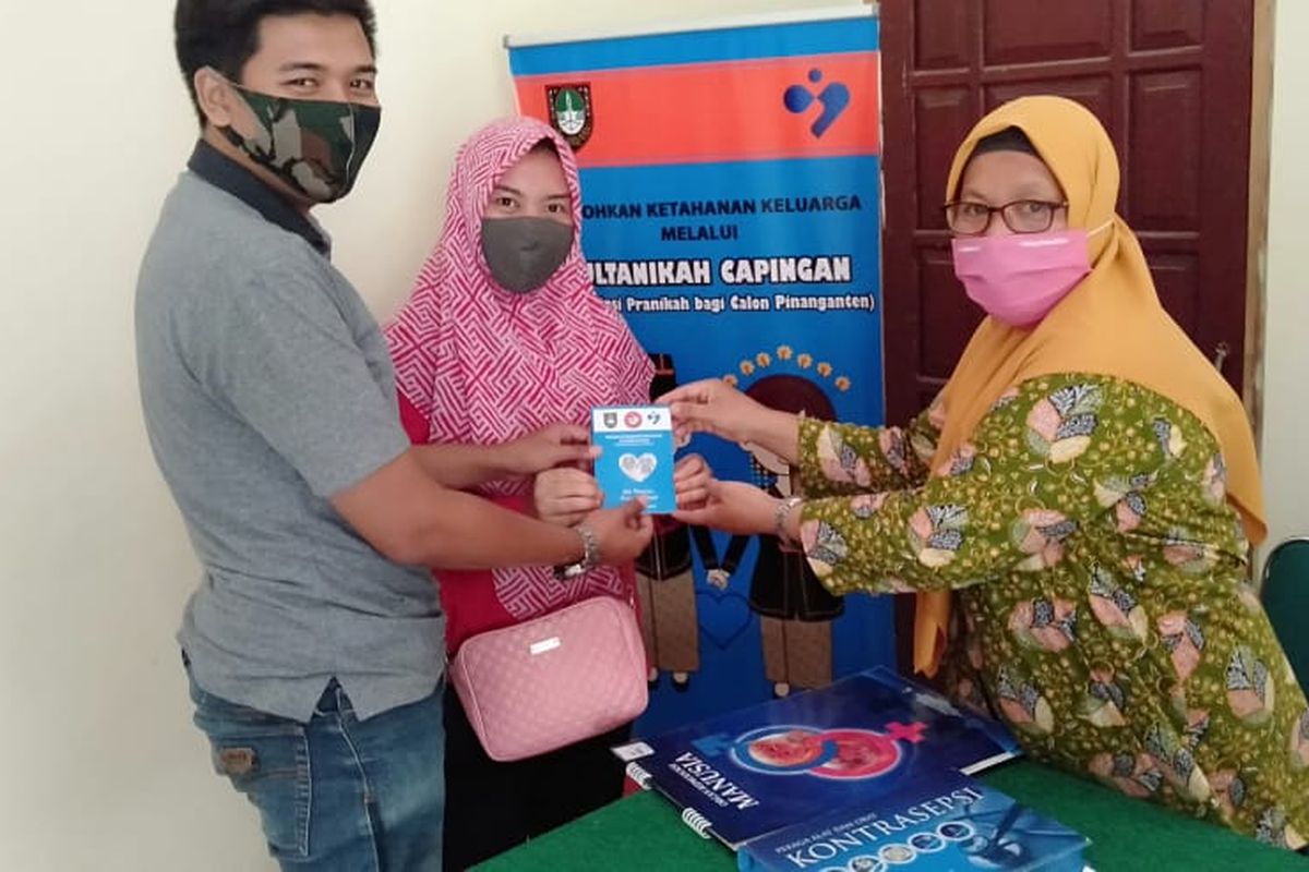 Petugas Lapangan Keluarga Berencana (PLKB) Dinas Pengendalian Pendudukan dan Keluarga Berencana (DPPKB) Solo (kanan) memberikan buku saku kepada calon pengantin dalam program Sultan Nikah Capingan (Konsultasi Pra Nikah Bagi Calon Pinanganten) belum lama ini.