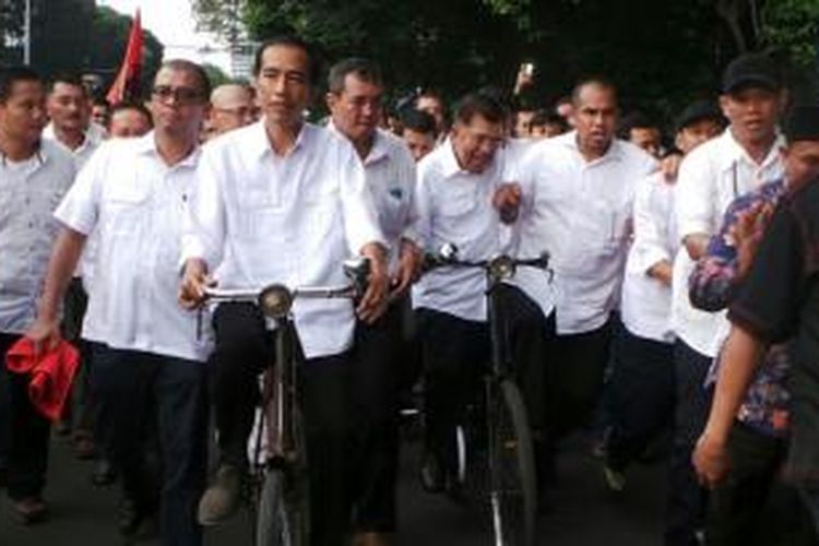 Pasangan bakal calon presiden dan wakil presiden, Joko Widodo dan Jusuf Kalla, Senin (19/5/2014), bersepeda bersama menuju Komisi Pemilihan Umum untuk mendaftarkan diri.