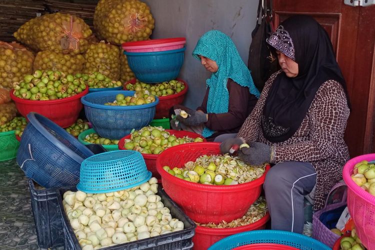Ibu-ibu di Dusun Kekep, Desa Tulungrejo, Kota Batu yang bekerja di tempat produksi keripik buah milik Lilik Sumarlik sedang mengupas apel pada Minggu (9/4/2023). 