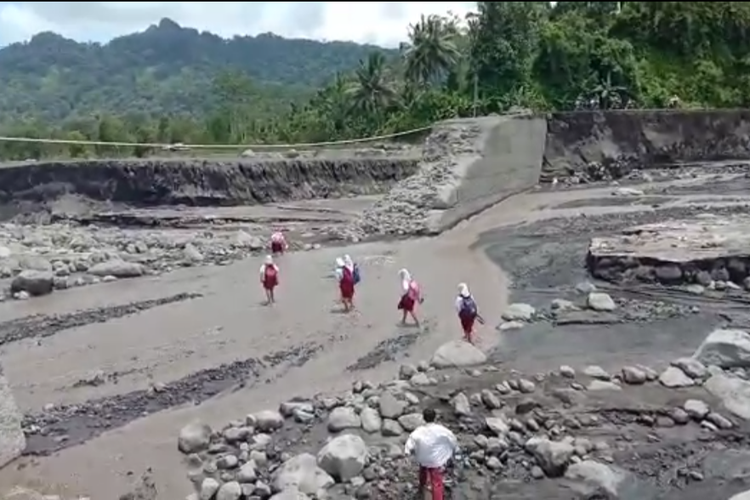 Suasana siswa SDN Jugosari 3 saat menyebrangi aliran sungai pasca jebolnya jembatan Jugosari, Selasa (8/3/2022)