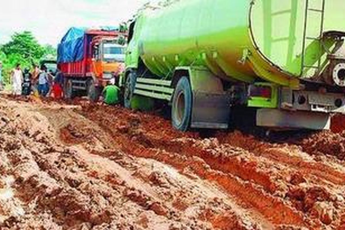 Truk terjebak dalam kubangan lumpur di Desa Tanjungpauh, Mestong, Kabupaten Muaro Jambi, Provinsi Jambi, Sabtu (19/12/2010). Jalan utama penghubung jalur tengah Sumatera, mulai dari Palembang-Jambi-Padang, ini sudah rusak sejak dua bulan lalu. 