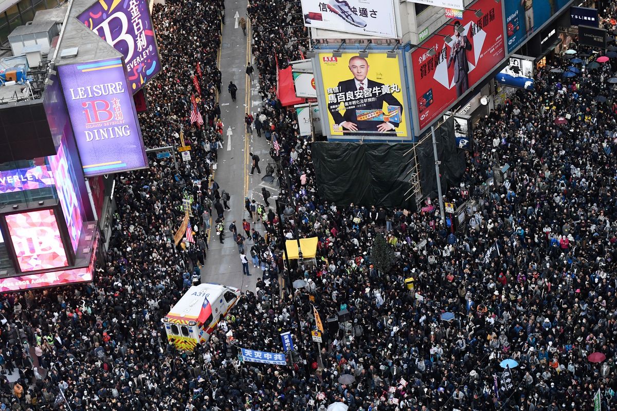 Ratusan ribu massa memberikan jalan bagi ambulans selama aksi damai yang terjadi Causeway Bay, Hong Kong, pada 8 Desember 2019. Aksi tersebut dilakukan jelang enam bulan demonstrasi yang melanda kota itu.