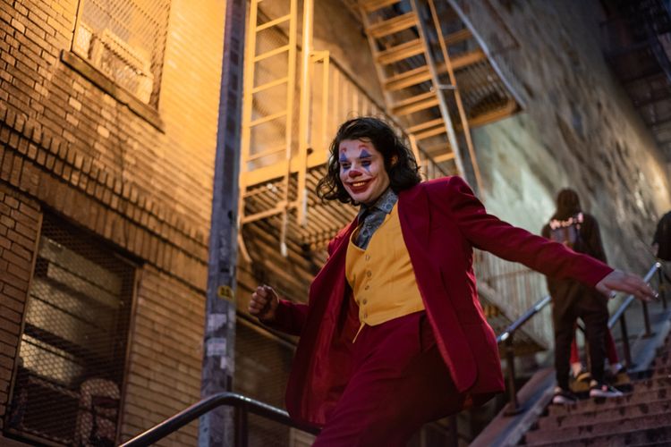 Seseroang berpenampilan layaknya Joker menari di tangga, di Bronx.