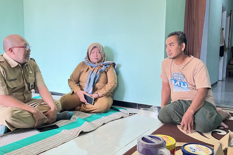 Suami Siti Khotimah, Sutiono saat dikunjungi oleh Kepala Bidang Penempatan Tenaga Kerja Dinas Tenaga Kerja (Disnaker) Kabupaten Malang Tri Darmawan, Senin (1/12/2025).