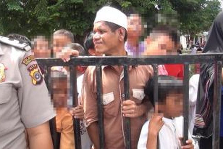 Walau sudah dilarang berada di lokasi ekseskui, sejumlah anak-anak tetap berada dibalik pagar arena eksekusi cambuk, mereka tetap ingin menyaksikan prosesi hukuman cambuk bagi tiga pelaku judi sabung ayam, di Halaman Mesjid Tengku Dinajong Peulanggahan Banda Aceh, Jumat (6/11/2015) 