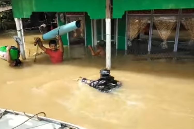 Salah seorang petugas TNI berupaya mengevakuasi warga yang terjebak banjir di Kecamatan Satui, Kabupaten Tanah Bumbu, Kalsel, Sabtu (8/6/2024).