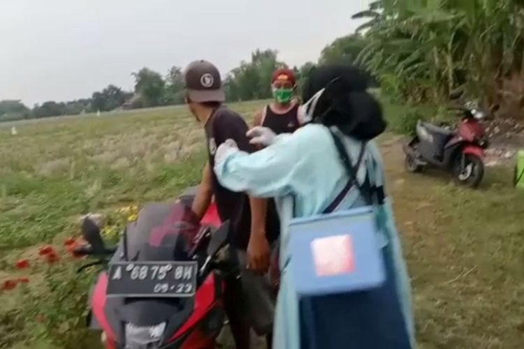 Tangkapan layar dari video petugas kesehatan mendatangi petani di sawah dan membujuknya agar mau melakukan vaksinasi Covid-19.