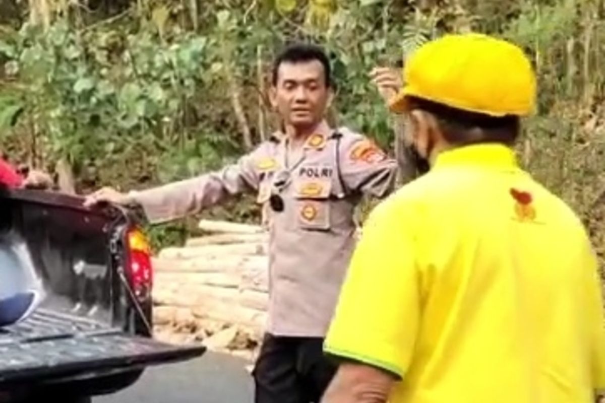 Kapolsek Girisubo AKP Agus Supriyanta, saat membantu wisatawan asal Madiun di Tanjakan Gedang Klutuk, Girisubo. Rabu 4 Oktober 2023
