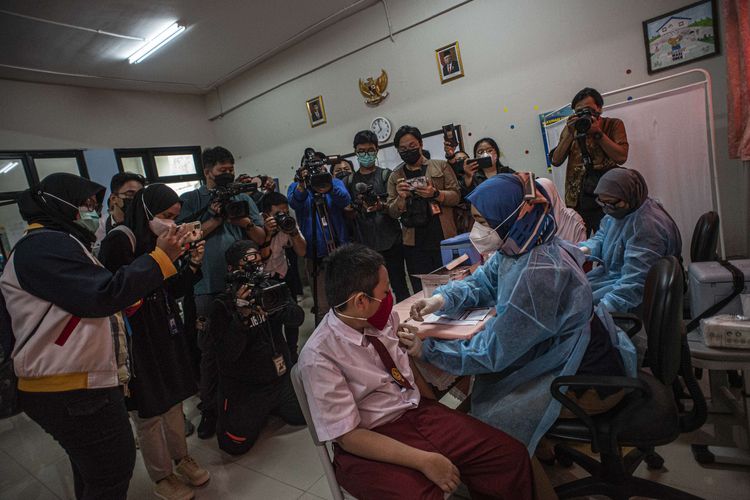 Tenaga kesehatan (kanan) menyuntikkan vaksinasi Covid-19 kepada pelajar di SDN Cempaka Putih Timur 03, Jakarta, Selasa (14/12/2021). Kementerian Kesehatan memulai vaksinasi Covid-19 untuk anak usia 6-11 dengan jumlah sasaran vaksinasi mencapai 26,5 juta di Indonesia.