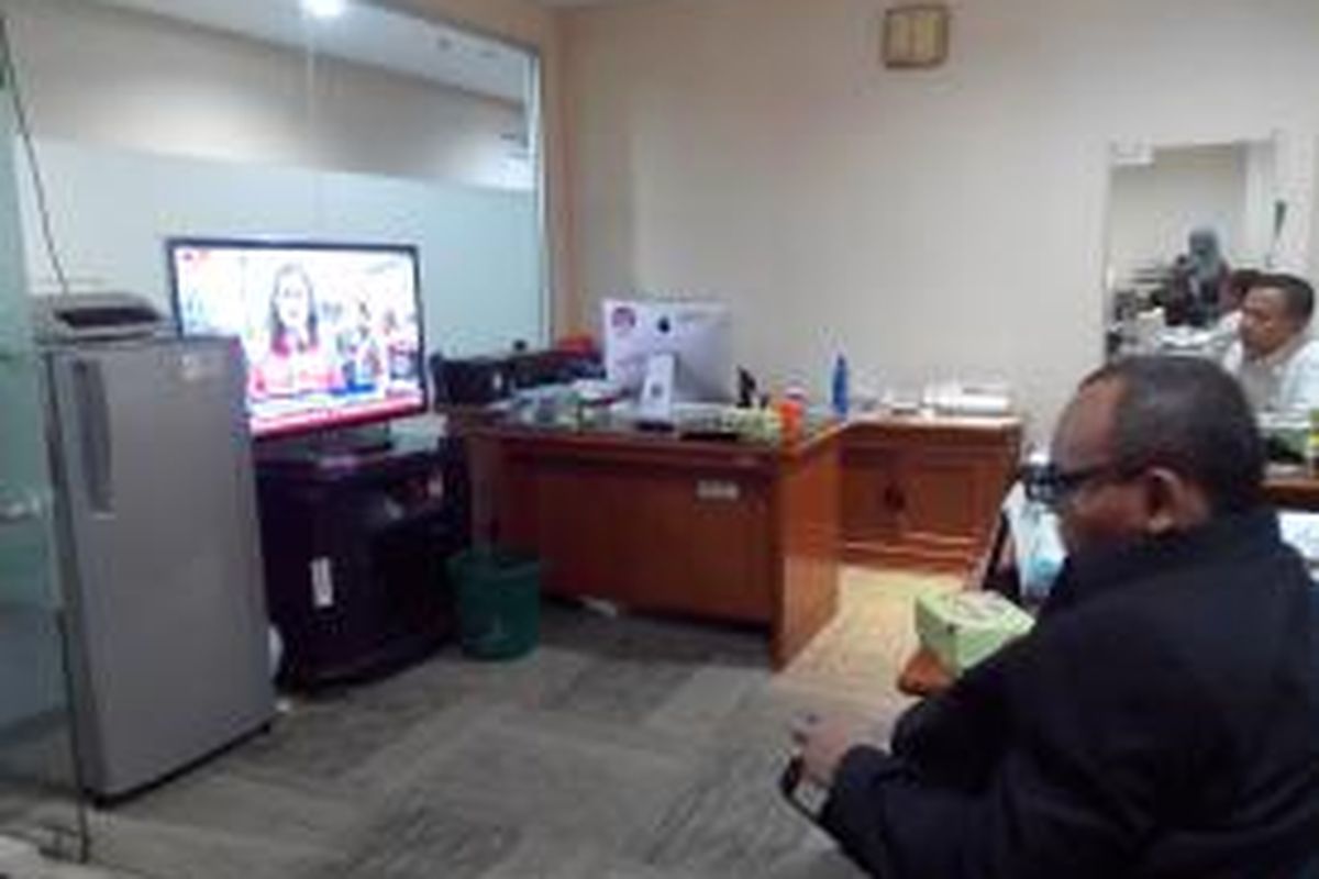 Beberapa anggota DPRD menonton siaran televisi tentang penggusuran warga Kampung Pulo. 