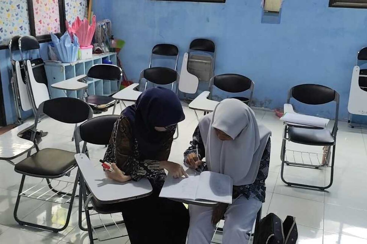 Indah berkerudung hitam sedang mengajarkan matematika terhadap Salwa di SMK Cipto Kota Cirebon pada Kamis (7/8/2025) siang.