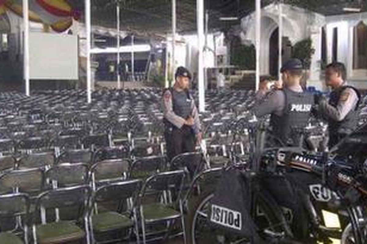 Polisi mensterilisasi gereja sebelum misa dimulai untuk menjamin keamanan umat yang hendak beribadah.