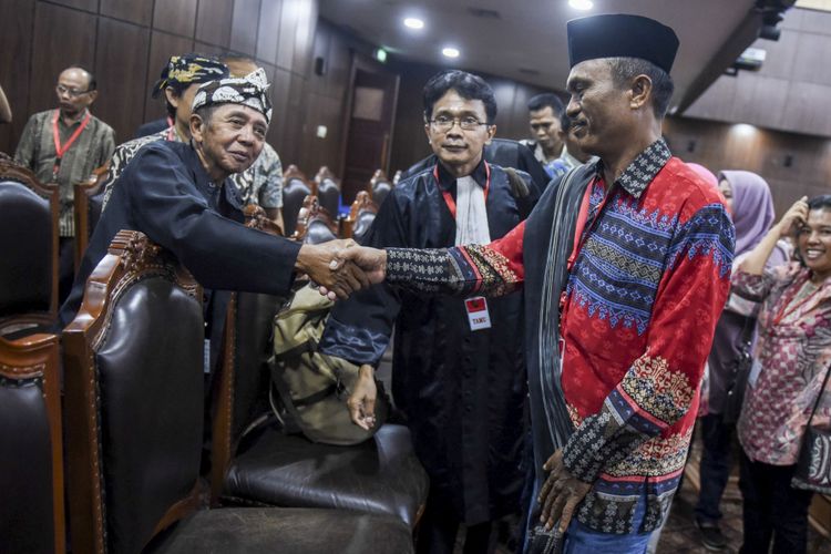 Penganut kepercayaan Ugamo Bangsa Batak Arnol Purba (kanan) yang juga selaku pemohon berjabat tangan dengan penganut kepercayaan lainnya yang menyaksikan sidang seusai pembacaan putusan uji materi Undang-Undang Nomor 24 Tahun 2013 tentang Administrasi Kependudukan di Mahkamah Konstitusi, Jakarta, Selasa (7/11/2017). MK mengabulkan permohonan uji materi atas Pasal 61 Undang-Undang Nomor 23 Tahun 2006 dan Pasal 64 Undang-Undang Nomor 24 Tahun 2013 tentang Administrasi Kependudukan terkait pengisian kolom agama di KTP bagi penganut kepercayaan yang selama ini dikosongkan.