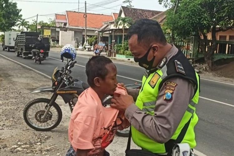 Tangkapan layar Aipda Purnomo sedang memakaikan pakaian kepada perempuan ODGJ di Babat, Jombang.