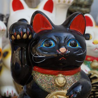 Ilustrasi patung kucing keberuntungan atau Maneki Neko dalam feng shui.
