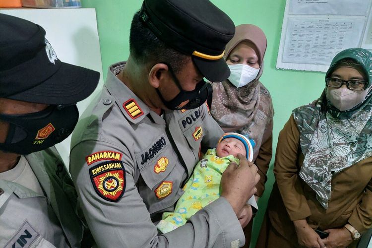 Kapolsek Dander AKP Jadmiko menggendong bayi yang ditemukan warga Desa Sumberarum, Kecamatan Dander, Kabupaten Bojonegoro, Jawa Timur. (Selasa/27/9/2022)