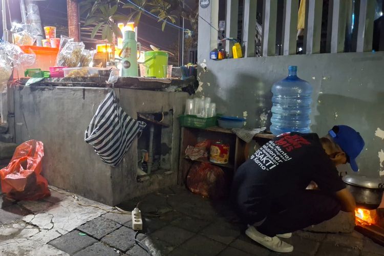 Rombli, (32), pedagang nasi jinggo, terpaksa memasak pakai tungku berbahan kayu bakar karena kesulitan mendapat gas elpiji 3 kilogram di Jalan Setia Budi, Kuta, Kabupaten Bandung, Bali, pada (3/2/2025). 
