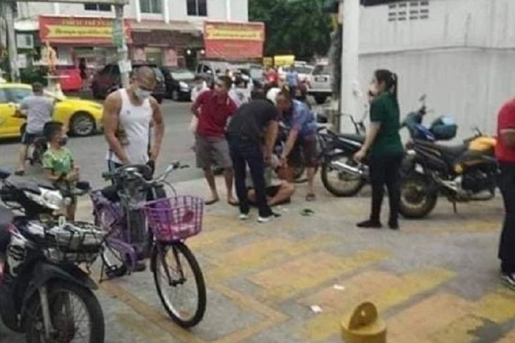 Seorang pencuri (terduduk) di Thailand ditangkap oleh polisi dan diseret sekelompok orang saat melakukan aksinya di supermarket. Dia mengaku mencuri karena kehilangan pekerjaan dan tidak punya uang untuk makan.