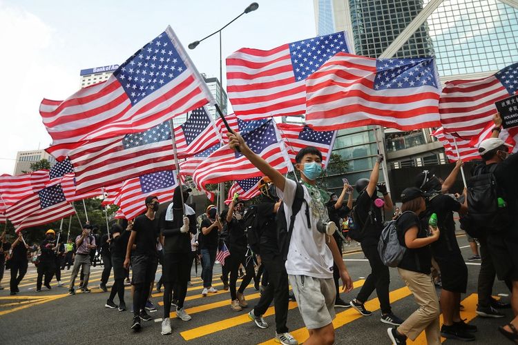 Pengunjuk rasa dalam aksi demonstrasi di Hong Kong membawa dan mengibarkan bendera Amerika Serikat, saat melakukan aksinya pada Minggu (8/9/2019). Mereka menyerukan agar AS dan Presiden Donald Trump turut membantu Hong Kong agar bebas dari China.