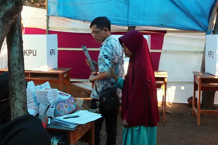 Indra Rukmana penyandang disabilitas tuna netra didampingi ibunya Arum Sari hendak menunaikan hak pilihnya di TPS 10, Desa Sindang Laut, Kecamatan Lemahabang, Kabupaten Cirebon, Rabu (17/4/2019). Indra menilai persiapan dan pelaksanaan pemilu 2019 masih penuh batas untuk penyandang disabilitas. 