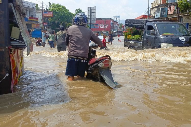 Sejumlah pengendara baik roda dua dan empat saat berupaya melintasi,, Jalan Raya Dayeuhkolot, Kabupaten Bandung, Jawa Barat, yang tergenang luapan sungai Citarum setinggi 70 sentimeter, Senin (3/11/2025)