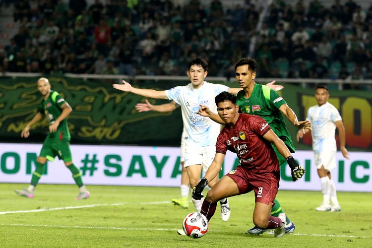 Penjaga gawang PSIM Yogyakarta Cahya Supriadi berhasil menghalau tendangan pemain Persebaya Surabaya Rizky Dwi Pangestu saat laga pekan pertama Super League 2025-2026 yang berakhir dengan skor 0-1 di Stadion Gelora Bung Tomo Surabaya, Jawa Timur, Jumat (8/8/2025) malam.