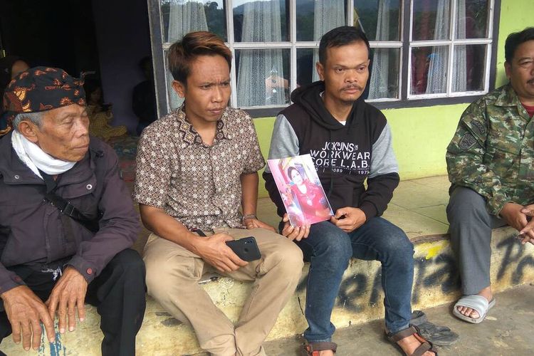 Yoyon (sweater hitam-abu) menunjukkan foto almarhum istrinya Enok yang turut menjadi korban dalam Kecelakaan bus peziarah di Desa Payungsari Kecamatan Panumbangan Kabupaten Ciamis, Minggu (22/5/2022).
