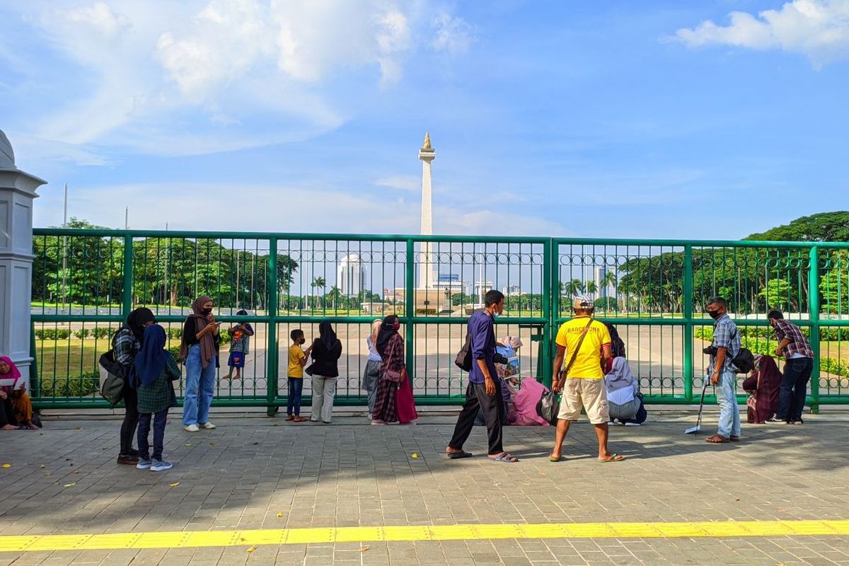 Pengunjung kawasan Monumen Nasional mulai berdatangan jelang malam pergantian tahun 2022, Jumat (31/12/2021). Monas dibuka lagi per Kamis (16/6/2022).