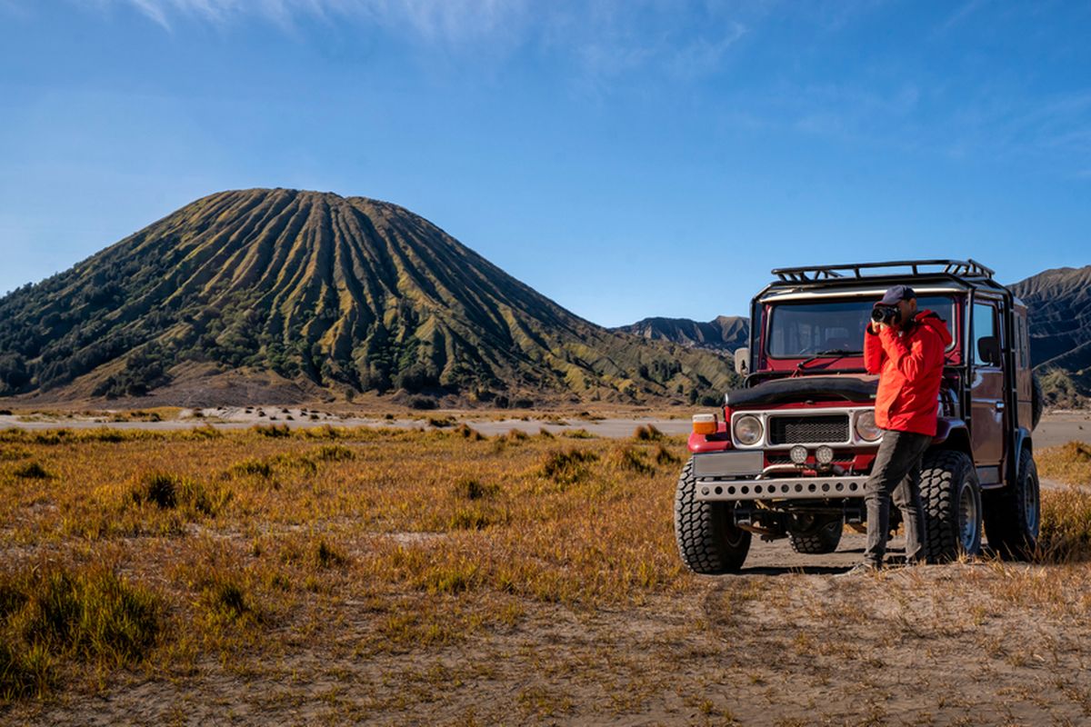 Ilustrasi  wisatwan berpose bersama jip di kawasan Bromo.