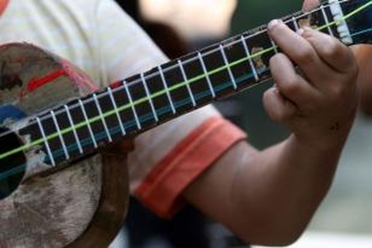 Dion (14) anak jalanan yang biasa mangkal di kawasan Menteng bermain gitar di Taman Menteng, Jakarta, Selasa (26/3/2013). Dion bersama anak jalanan lain dan aktivis anak Seto Mulyadi, artis Atiqah Hasiholan, serta Wakil Ketua DPD RI GKR Hemas menghadiri peluncuran program 'Bebas dari Jalan' dengan kampanye 'Jangan Beri Uang di Jalan', dengan tujuan pengentasan anak jalanan di Indonesia.