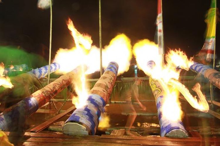 Suasana kemeriahan permainan meriam karbit di tepi Sungai Kapuas saat malam takbiran.