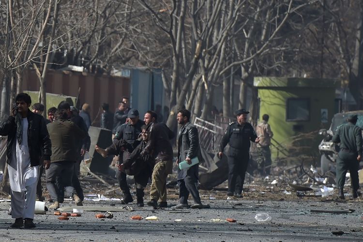 Relawan dan polisi Afghanistan membantu korban luka di lokasi bom mobil yang  meledak di depan gedung Kementerian Dalam Negeri lama di Kabul, Afghanistan, Sabtu (27/1/2018). (AFP/Wakil Kohsar)