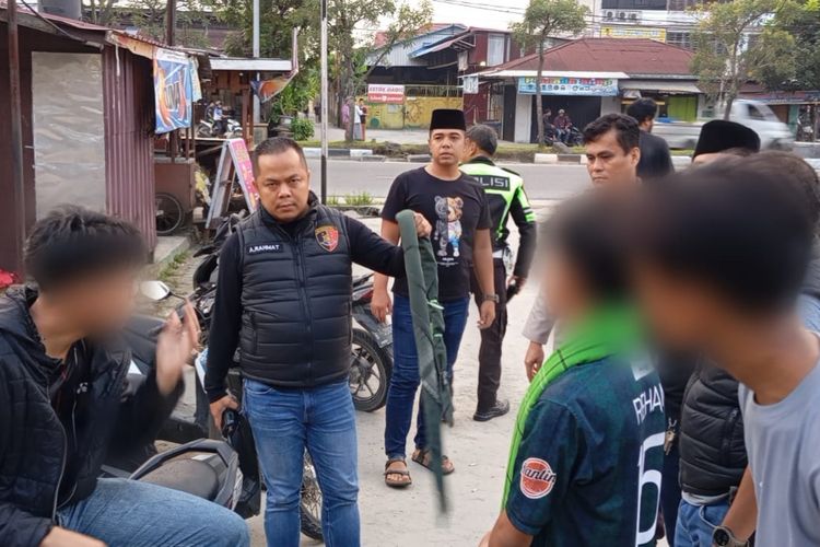 Petugas kepolisian saat mengamankan tiga pelajar yang hendak melakukan perang sarung dan menyerahkan warga, di kawasan Jalan HR Soebrantas, Kota Pekanbaru, Riau, Minggu (17/3/2024).