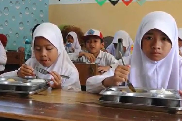 Siswi sekolah dasar menikmati menu MBG.