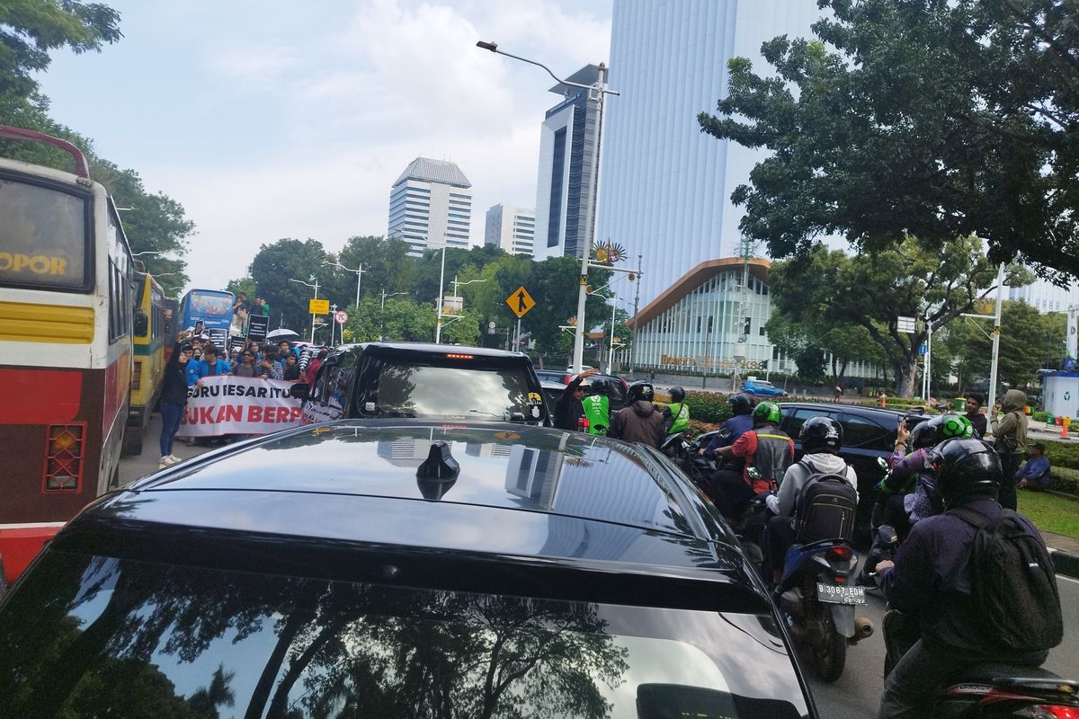 Mahasiswa longmarch dari Lapangan Parkir IRTI menuju Patung Kuda hingga sebabkan macet di Jalan Medan Merdeka Selatan, Gambir, Jakarta Pusat, Senin (12/2/2024).