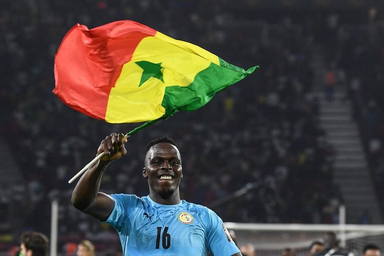 Edouard Mendy mengibarkan bendera Senegal setelah memenangi laga final Piala Afrika 2021 melawan Mesir di Stadion Olembe, Yaounde, Kamerun, Senin (7/2/2022) dini hari WIB.