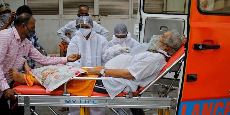 Seorang pasien memakai masker oksigen dibawa ke rumah sakit Covid-19 untuk dirawat di tengah penyebaran penyakit virus corona (Covid-19) di Ahmedabad, India, Senin (26/4/2021). India dihantam kengerian dengan lonjakan kasus Covid-19 mencetak rekor tertinggi dunia melampaui 17 juta kasus.