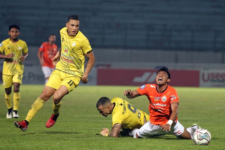 Pemain Persija Jakarta Maman Abdurrahman terjatuh seusai berebut bola dengan pemain Barito Putera Rafael De Oliviera dan Aleksandar Rakic saat pertandingan pekan 11 Liga 1 2021-2022 yang berakhir dengan skor 1-1 di Stadion Moch Soebroto Magelang, Jumat (5/11/2021) malam.