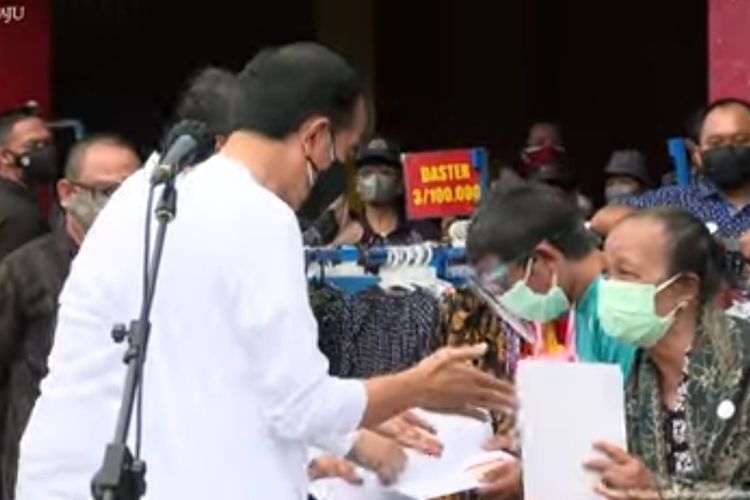 Presiden Joko Widodo berinteraksi dengan pedagang saat menyerahkan bantuan tunai kepada PKL dan warung kecil di Malioboro, Yogyakarta, Sabtu (9/10/2021).