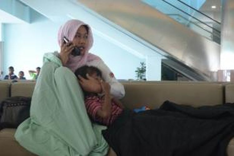 Salah seorang korban tenggelamnya kapal KM Wihan Sejahtera yang telah berhasil dievakuasi, menangis saat menelepon keluarganya, di Gapura Nusantara, Dermaga Tanjung Perak, Surabaya, Senin (16/11/2015).