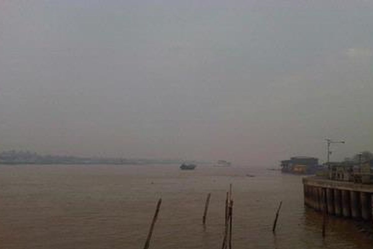 Perahu menembus kabut asap di Sungai Musi, Selasa (28/9/2011) pagi