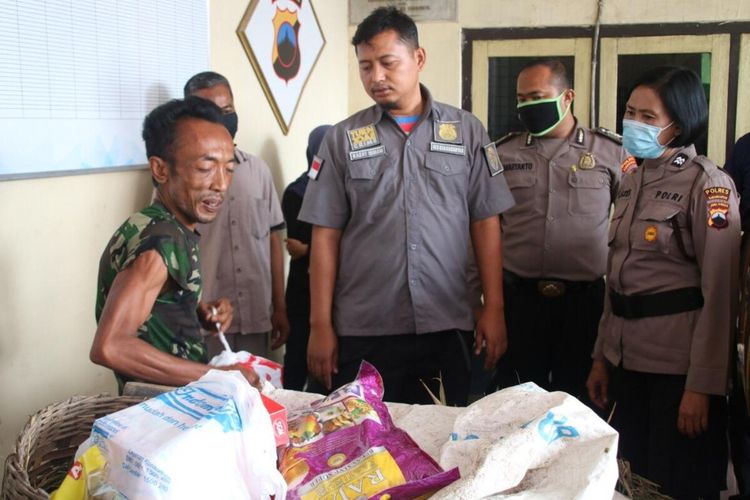 Kasat Reskrim Polres Karanganyar, AKP Ismanto Yuwono memberikan paket sembako kepada Sumardi, pemulung yang tertangkap karena mencuri padi di sawah di Karanganyar, Jawa Tengah.