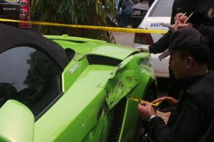 Lamborghini milik pengacara Hotman Paris Hutapea, yang alami kecelakaan diperiksa tim dari Labfor Mabes Polri. Senin (6/10/2014).
