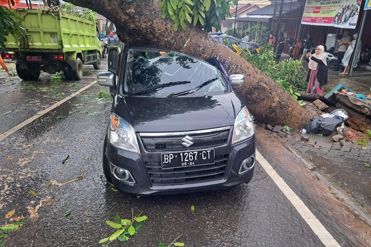 Sebuah mobil ditimpa pohon tumbang di jalan Engku Putri, Kota Tanjungpinang, Provinsi Kepri, Jumat (03/03/2023).