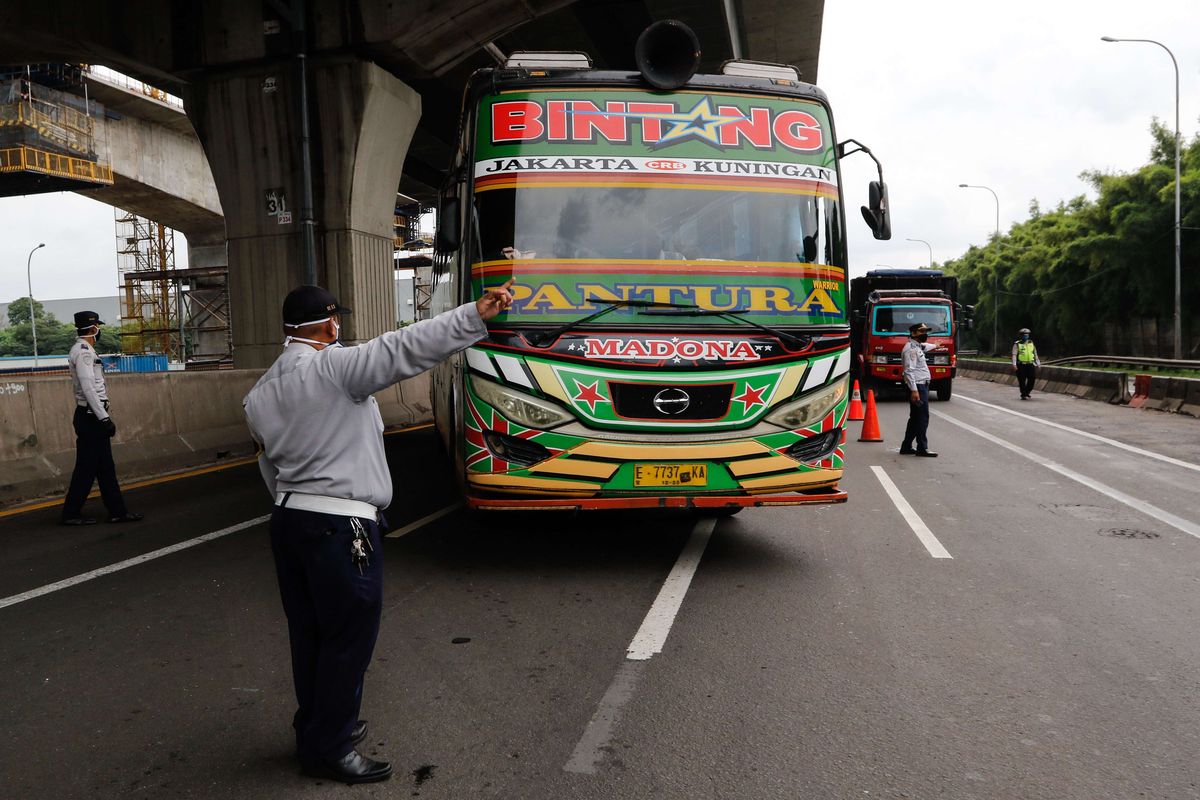 Petugas melakukan pemeriksaan di check point penyekatan pertama di ruas tol Jakarta - Cikampek Km 31, Kabupaten Bekasi, Jawa Barat, Jumat (24/4/2020). Larangan mudik mulai diberlakukan pemerintah mulai 24 April 2020 pukul 00.00 WIB untuk mencegah penyebaran Covid-19 melalui Operasi Ketupat 2020. Kendaraan pribadi baik motor atau mobil dan kendaraan umum berpenumpang dilarang keluar dari wilayah Jabodetabek.