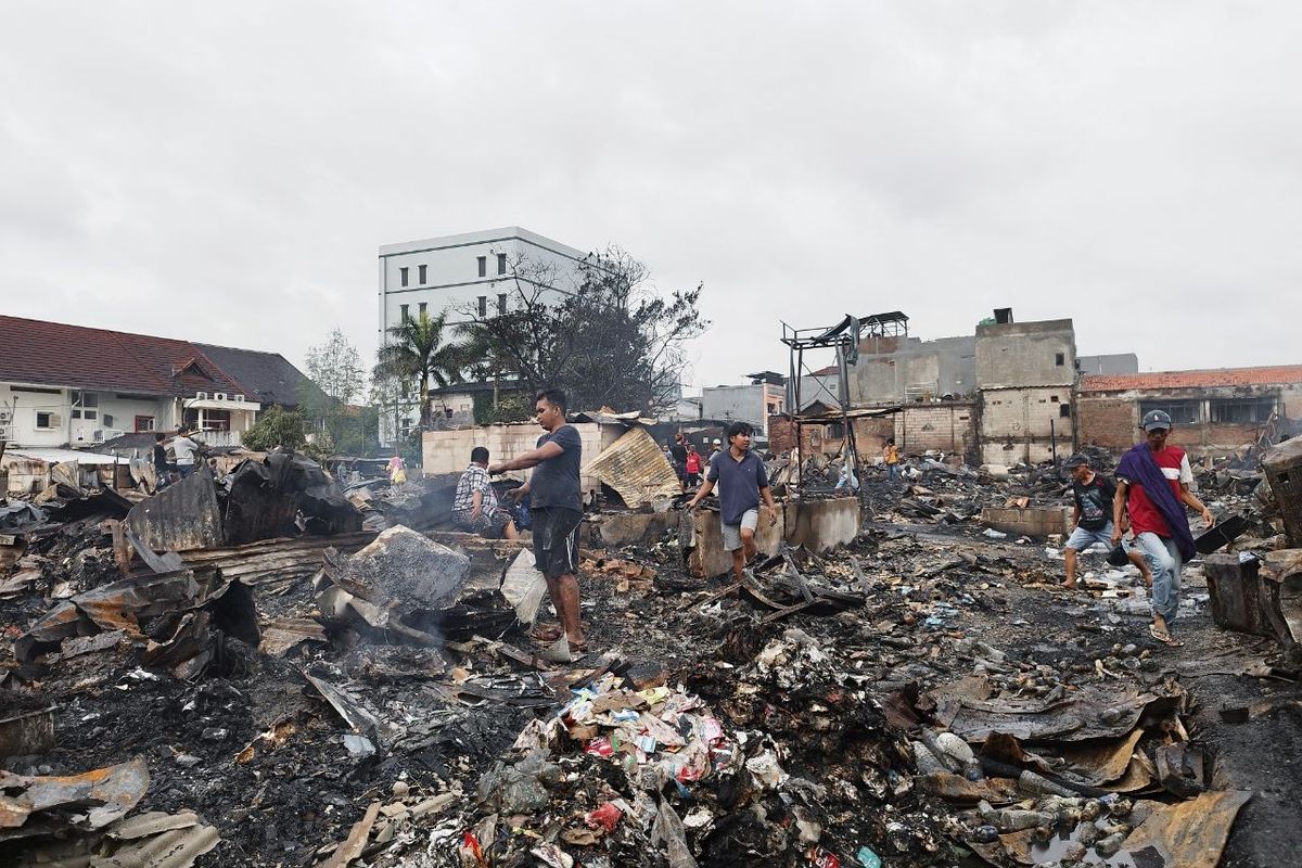 Warga sedang membereskan puing yang diluluhlantahkan oleh kebakaran di Jalan Tanah Abang V, Petojo Selatan, Gambir, Jakarta Pusat, Minggu malam, pada Senin (27/2/2023). (KOMPAS.com./XENA OLIVIA) 