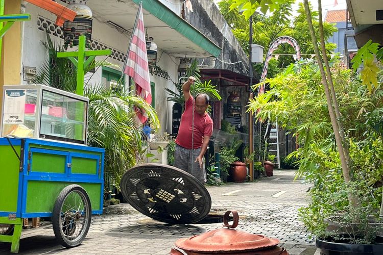 Juru pelihara Sumur Jobong, Agus Santoso saat melakukan pembersian air sumur dengan menyirami tanaman disekitarnya, Minggu (7/12/2025).