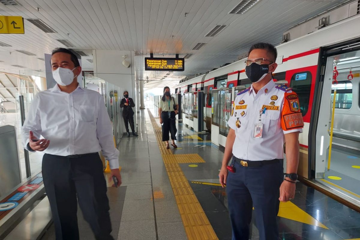 Kepala Dinas Perhubungan DKI Jakarta Syafrin Liputo (kanan) bersama bersama Direktur Utama PT JakLingko Indonesia Muhamad Kamaluddin (kiri) melakukan uji coba terbatas integrasi antarmoda dengan kartu dan aplikasi JakLingko di Stasiun Velodrome LRT Jakarta, Rabu (18/8/2021).